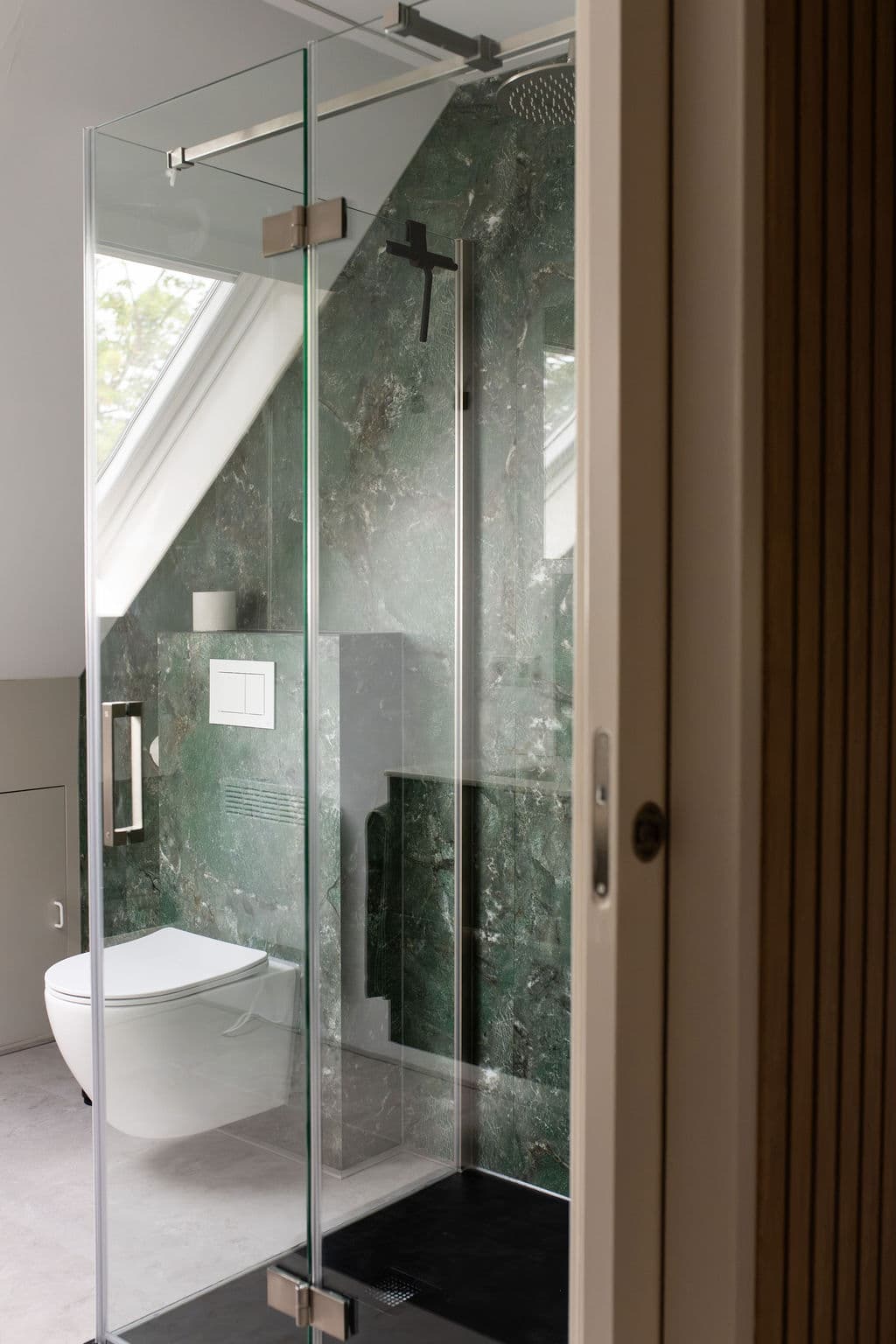 Blick ins obere Badezimmer mit Toilette und grünem Marmor