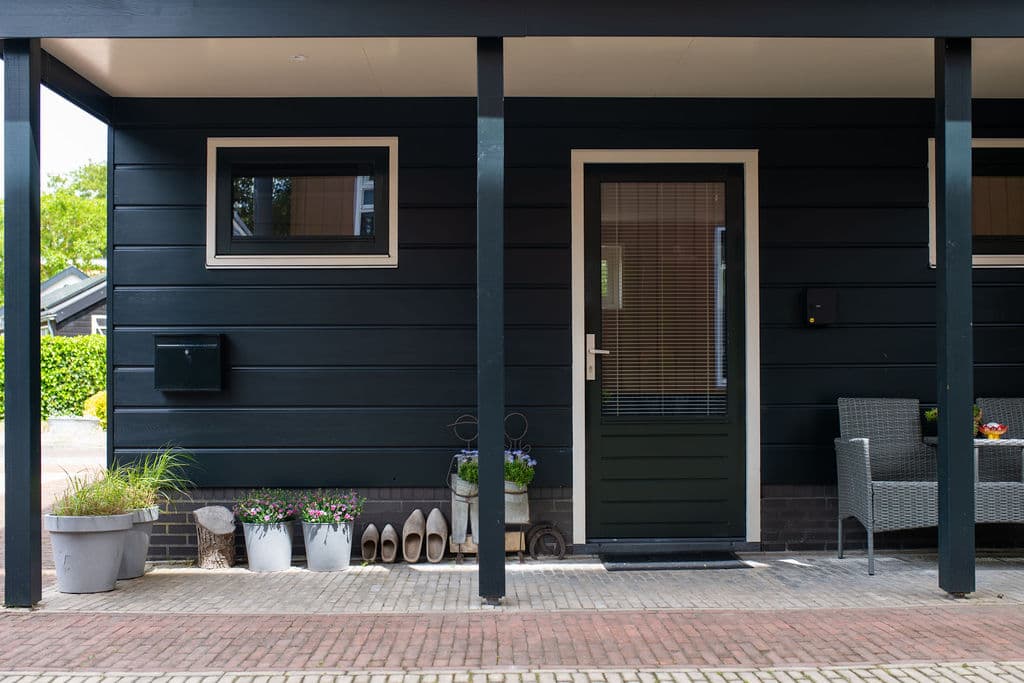 Vorderseite Appartement Hannes mit grüner Eingangstür und Pflanzkübeln
