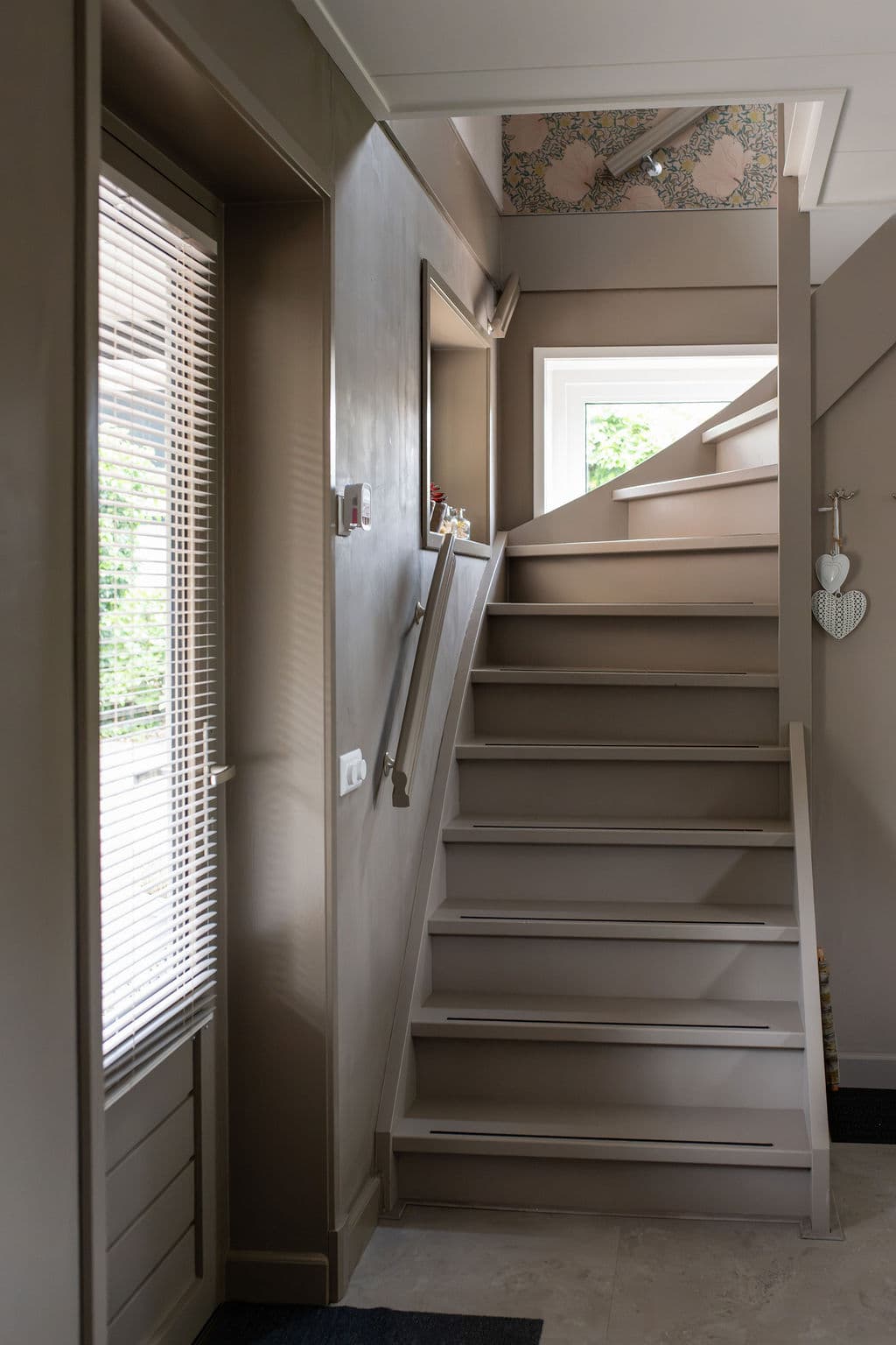 Treppe nach oben mit dekorativer Blumentapete an der Wand