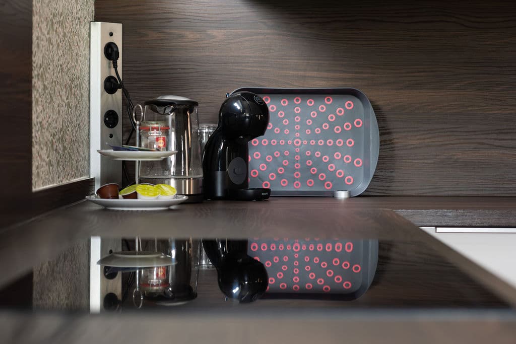Krups-Kaffeemaschine und Teestation auf dunkler Arbeitsplatte